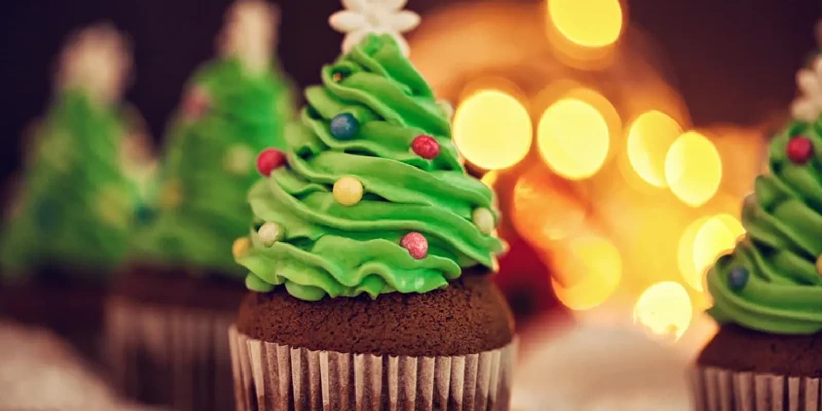 Chocolate cupcakes with green icing in the shape of a Christmas tree.